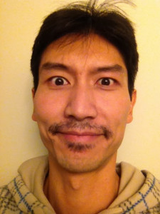 Lam Tang with a Movember moustache making a really weird face.